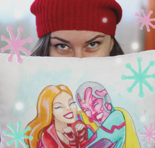 Taracosm holding up a pillow with a designs of Wanda & Vision